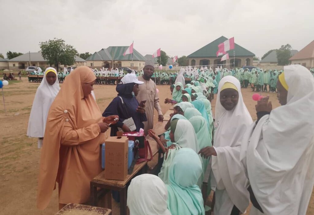 A group of people gather to receive the HPV vaccine in Nigeria