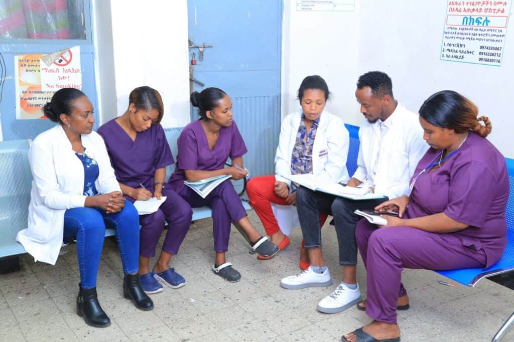 A group of health care professionals sit together looking at documents