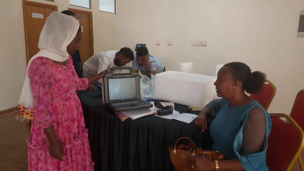 Health care professionals look at an ultrasound machine.