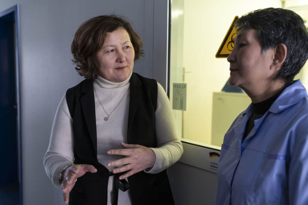 Two female medical professionals speak together.