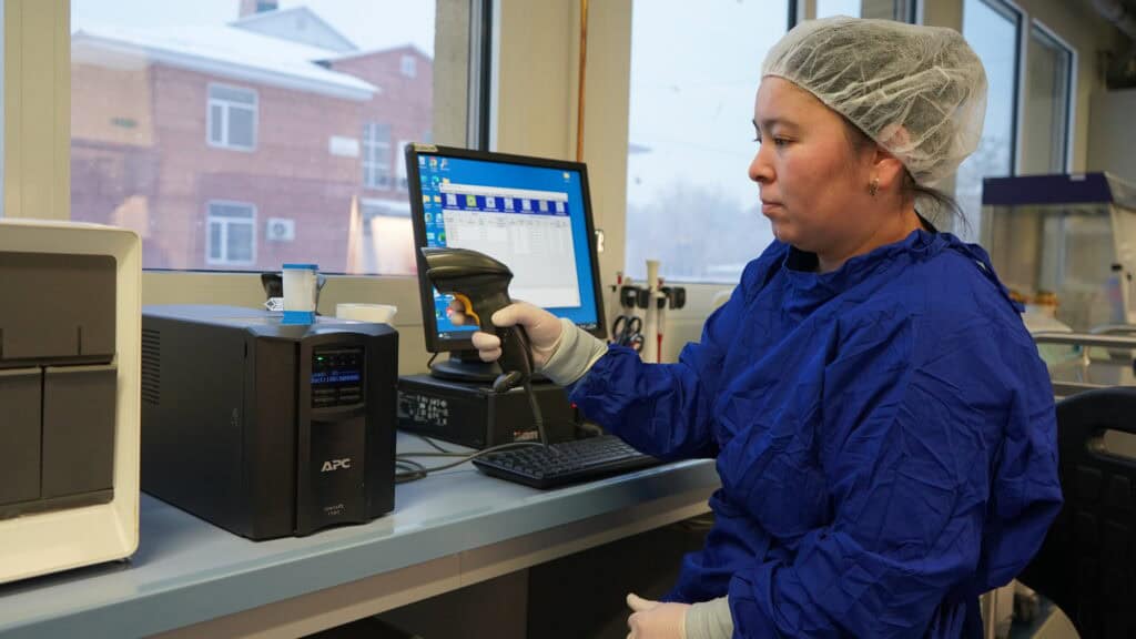 A laboratory worker registers a sample using tools and equipment.