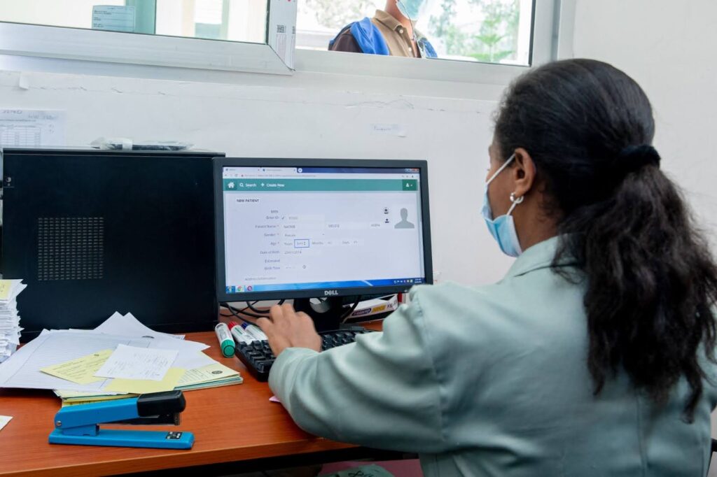 A medical professional reviews data on a computer.