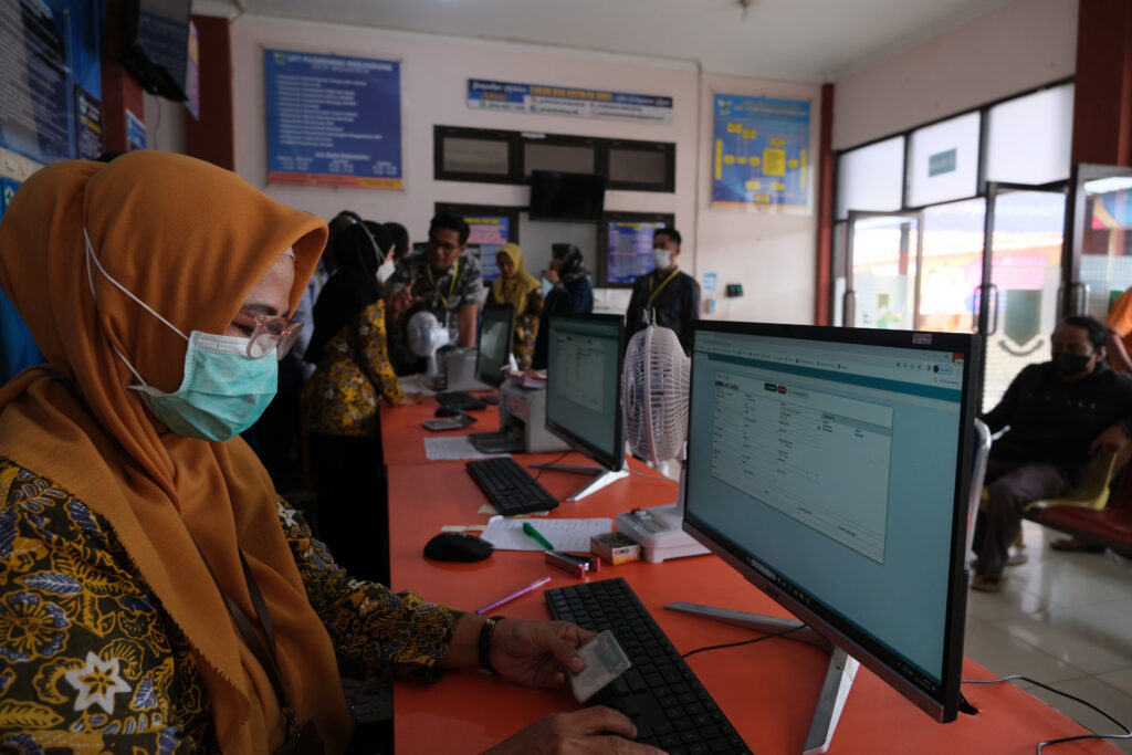 Health care worker entering data in Indonesia.