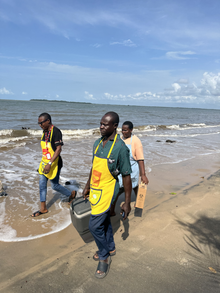 A vaccination team walks along a beach in Nigeria.