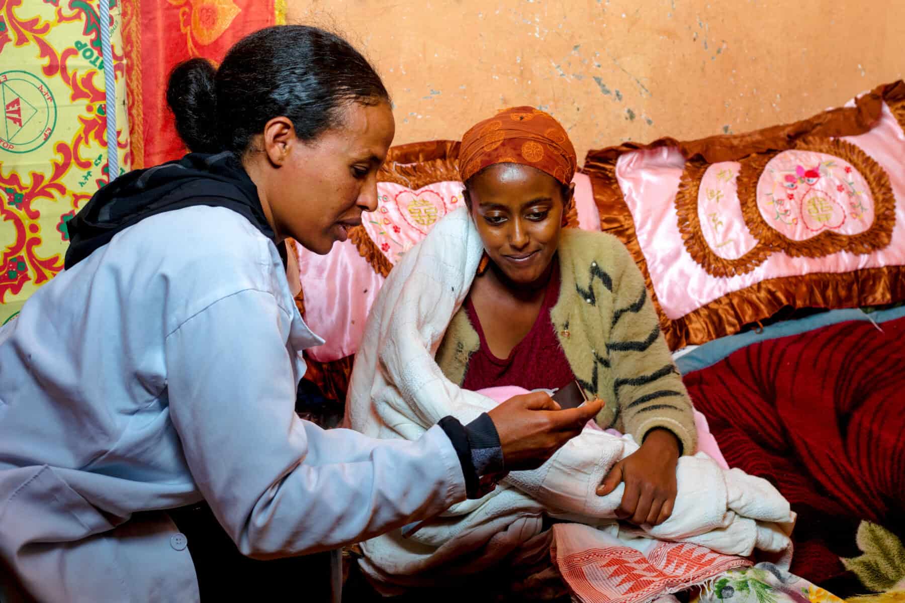 A community health worker monitors a new mother and her baby in Ethiopia.