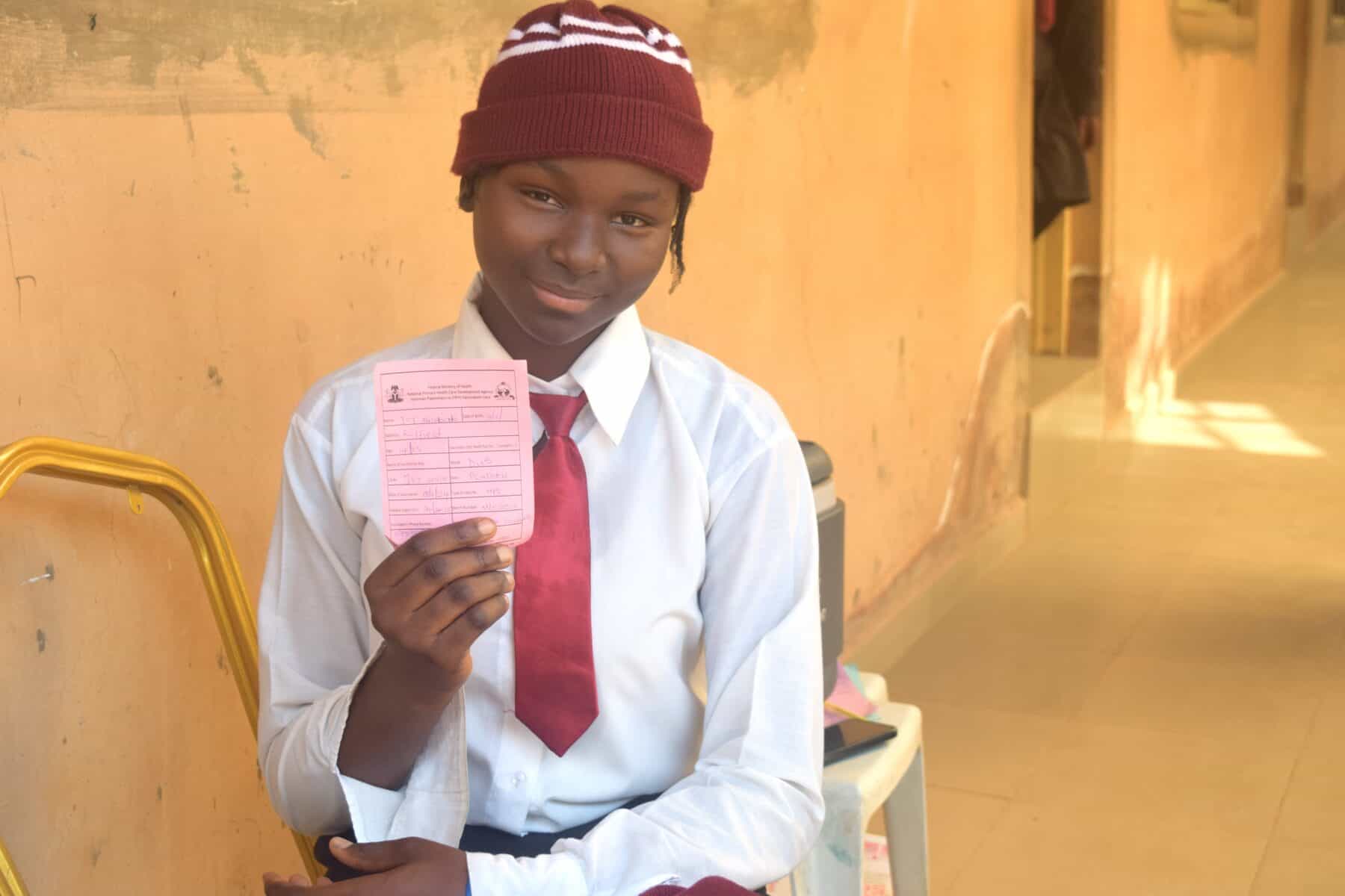 A student proudly displays her HPV vaccination card.