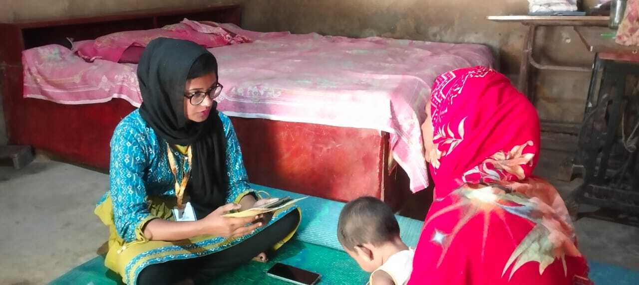 A health worker and caregiver discuss a child&rsquo;s immunization history.