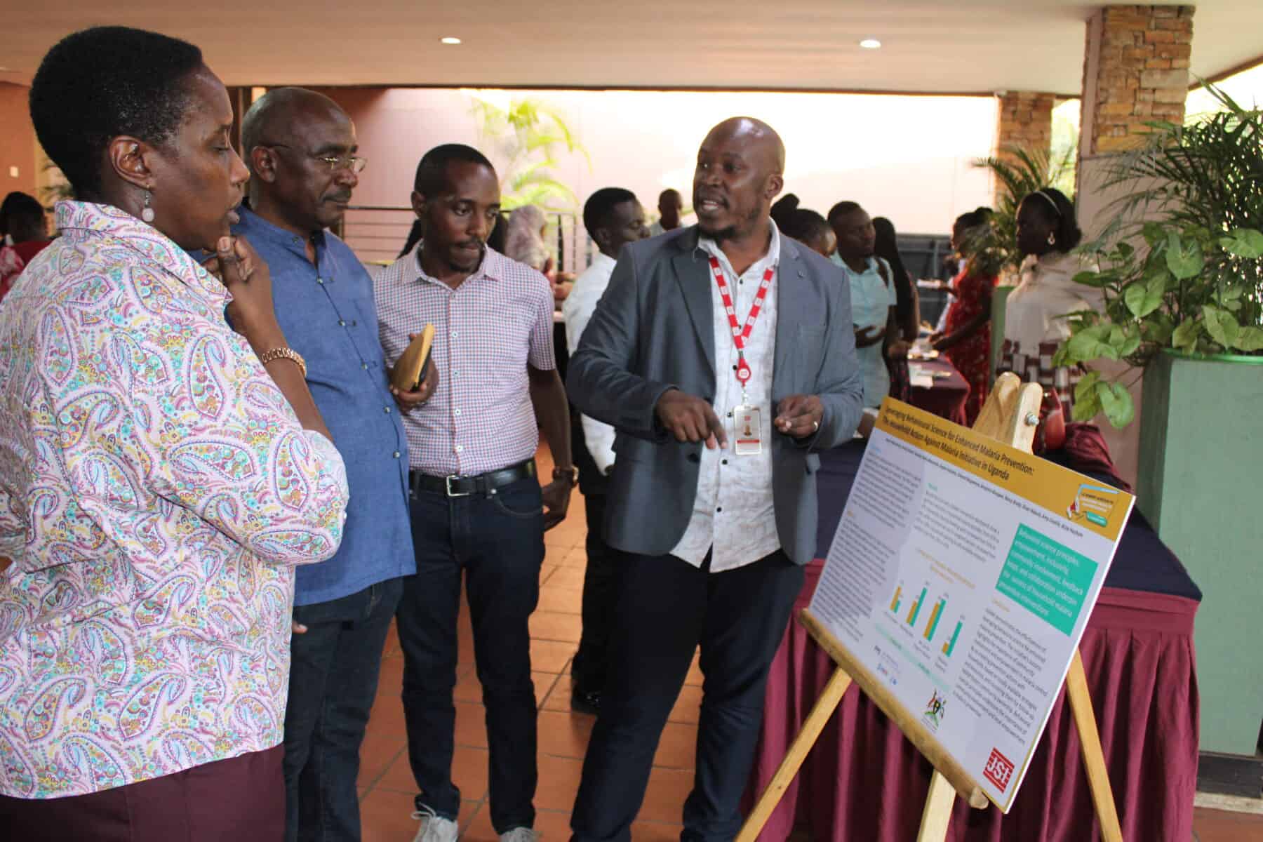 Aaron Musimenta presents on leveraging behavioral science for malaria prevention at the SBC Summit watch party in Kampala, Uganda.