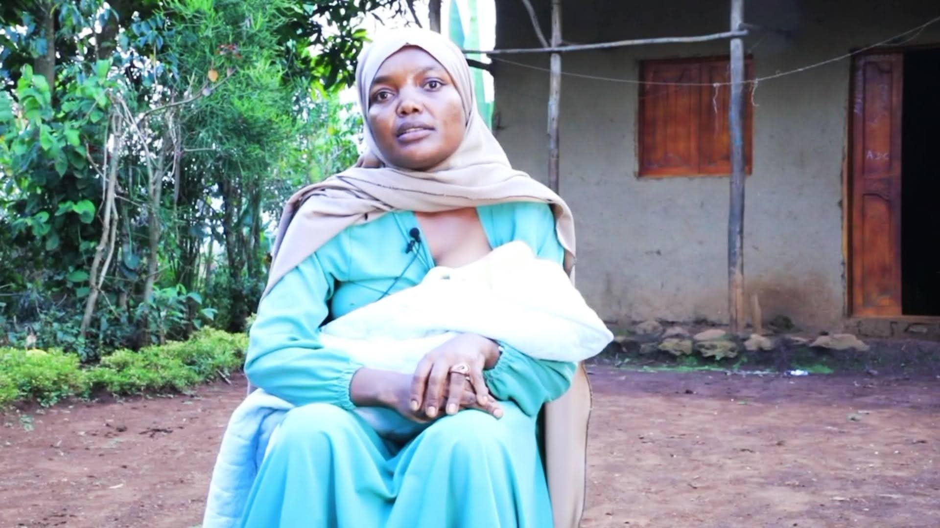 An Ethiopian mother holds her baby outside.