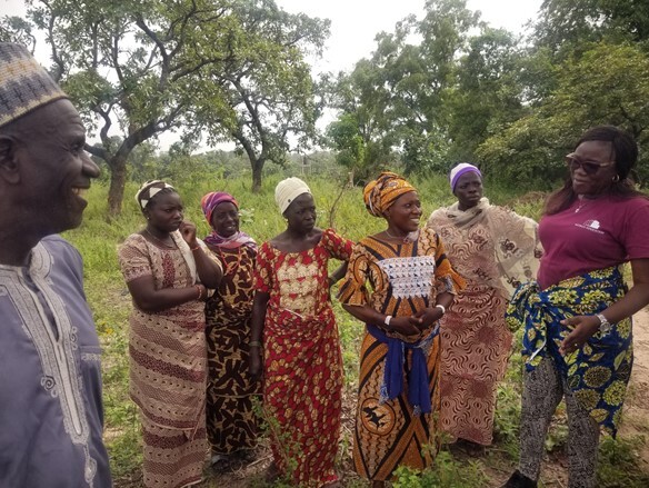 A group of people meet outside in Benin.