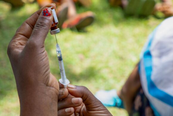 A closeup image of a person drawing medicine into a needle.