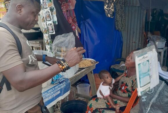 A health care worker speaks with a mother holding a child in Nigeria.