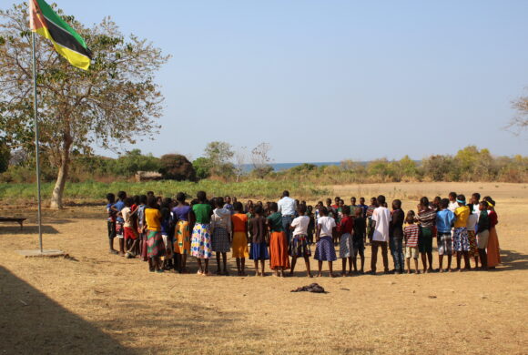 A teacher in Mozambique teaches his students outside.